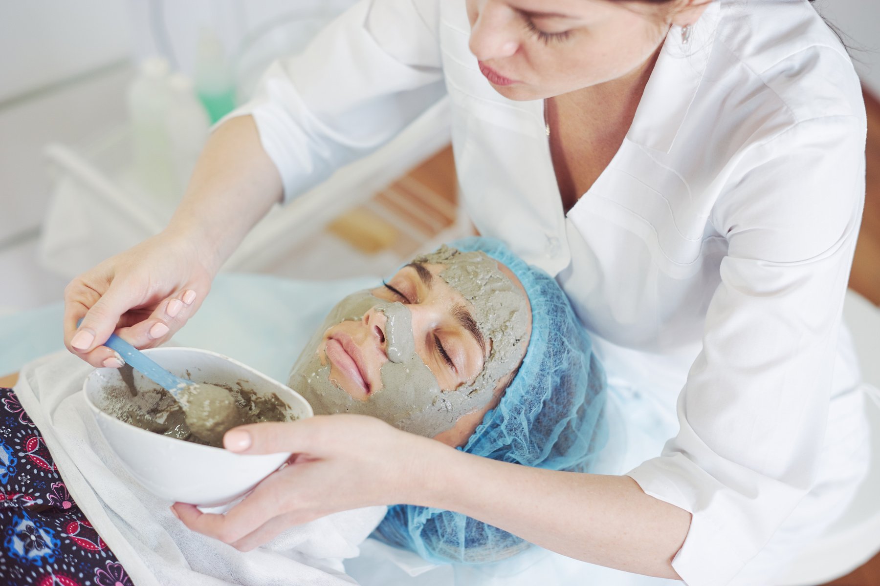 Cosmetologist applying mask made of algae.